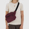 model wearing mahogany fanny pack with black trim across their chest