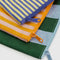 up close of set of three stripe pouches: small blue/yellow thin stripe, medium orange/pink stripe and large blue/green large stripe