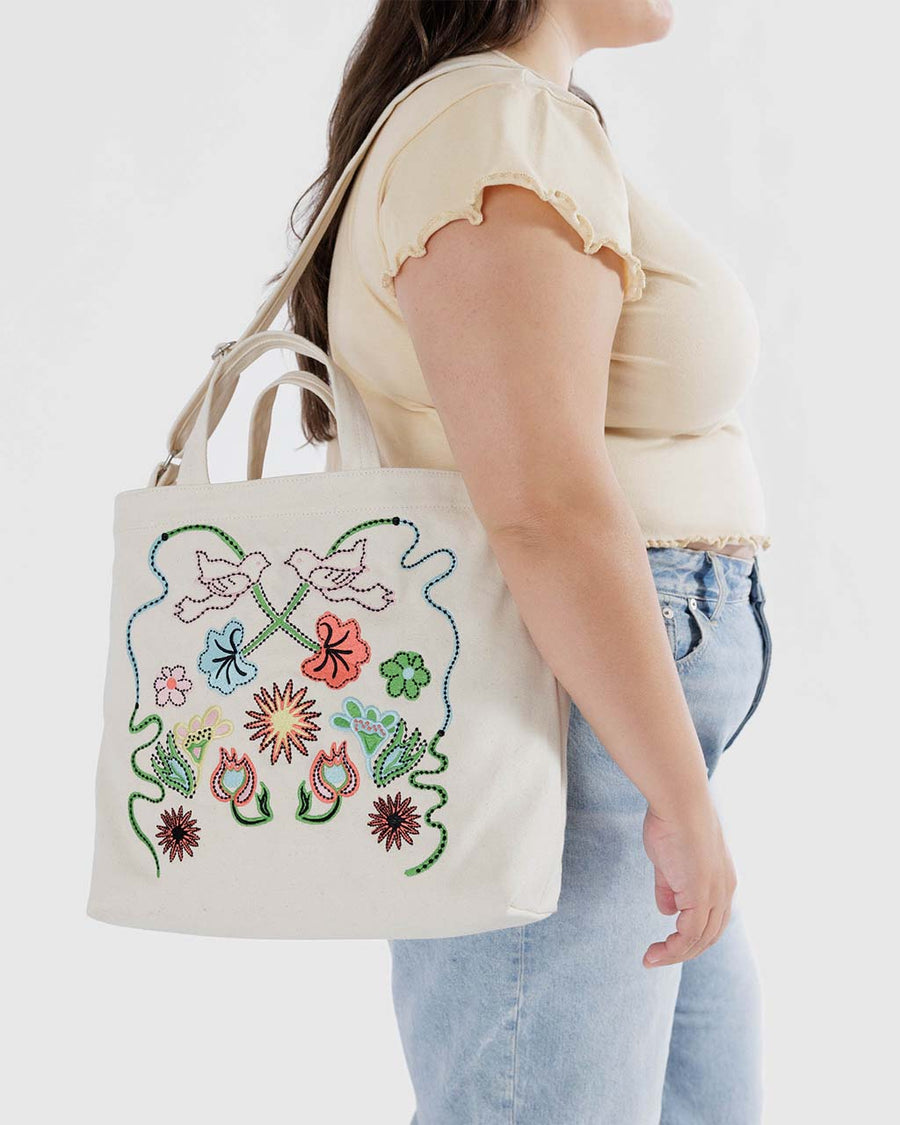 model carrying cream zip duck bag with embroidered floral and bird print