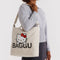 model carrying tan horiztonal zip duck bag with hello kitty face and large 'BAGGU' across the front