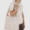model carrying cream horizontal zip duck bag with red painted wildflower print