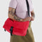 model wearing candy apple nylon messenger bag with black front buckle