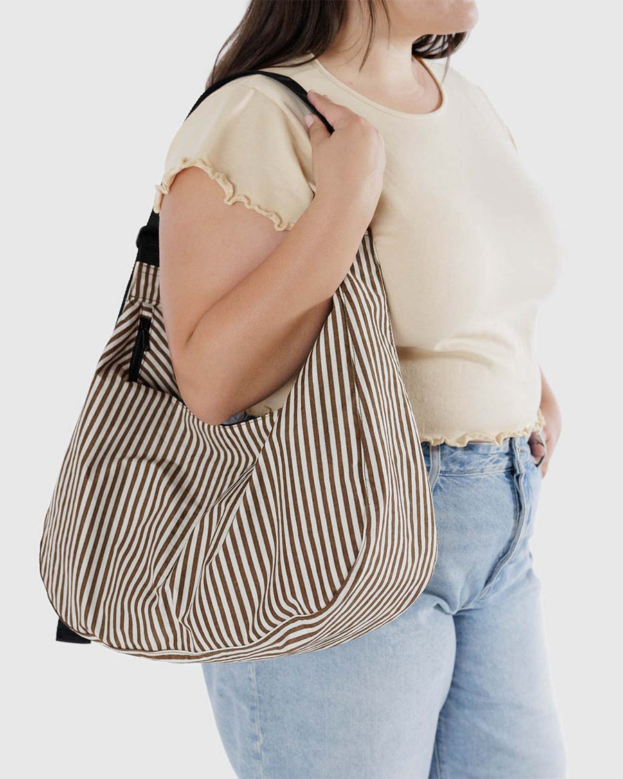 model carrying two tone brown vertical stripe large crescent bag