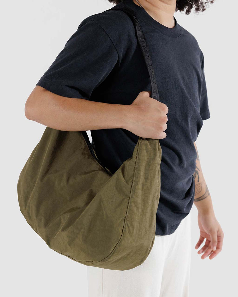 model wearing dark green large crescent baggu bag