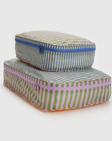 two large packing cube sets with various colorful stripe patterns and blue and lavender zippers
