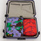 set of 2 large packing cubes: small red snapdragon, and large maroon poppy in a suitcase