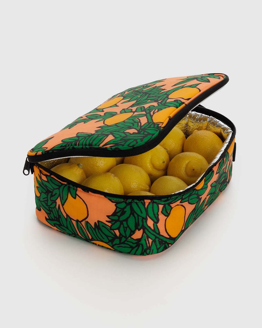 coral lunch bag with orange tree print with lemons inside of it