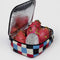 opened periwinkle, red, black and cream painted checker lunch box with black trim with dragonfruit inside