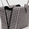 side view of medium nylon black and white gingham bowler bag