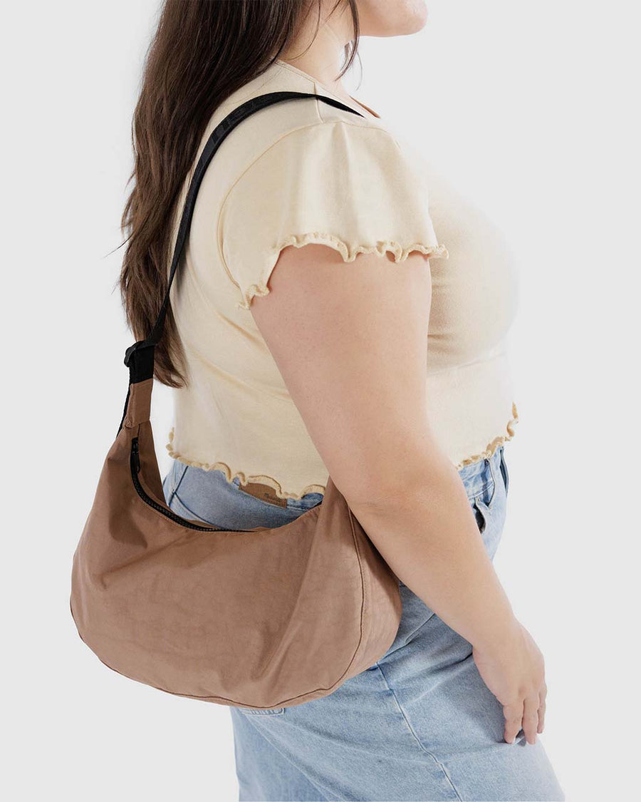 model wearing light brown medium crescent bag
