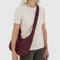 model wearing mahogany medium crescent bag with with matching trim