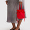 model holding red drawstring bag with handle
