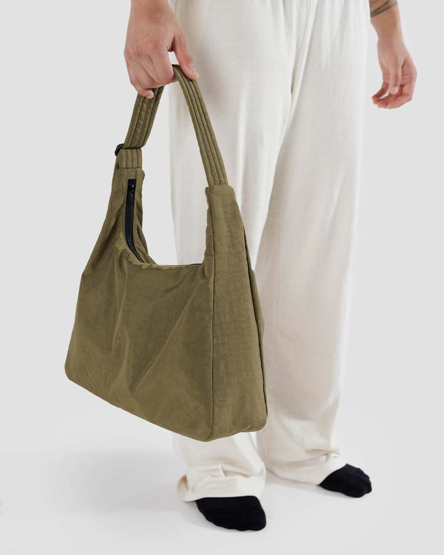 model holding dark green nylon shoulder bag