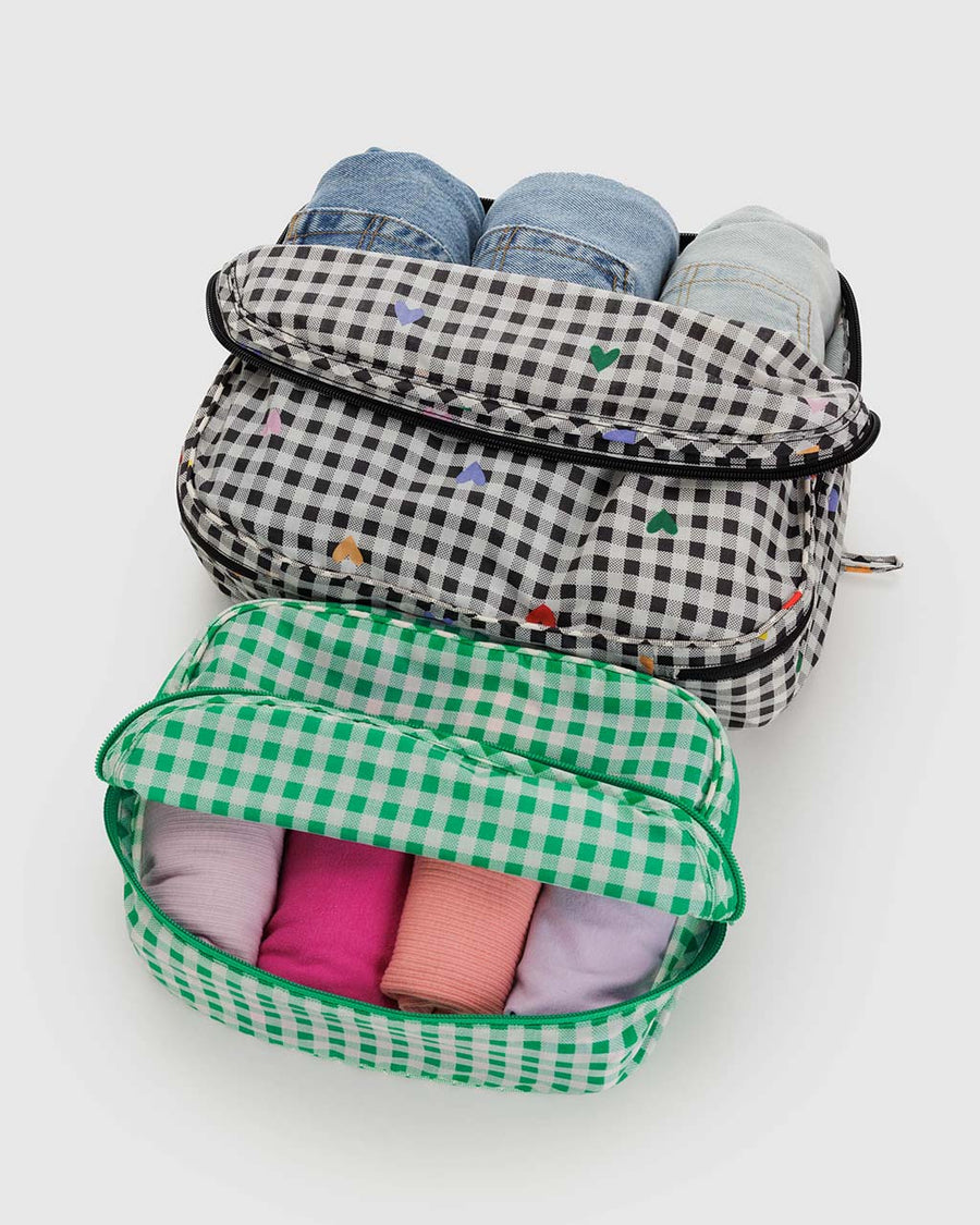 set of 2 packing cubes: green gingham and black and white gingham with colorful hearts with clothing inside