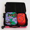 set of two packing cubes: small coral snapdragon and large maroon poppy in suitcase