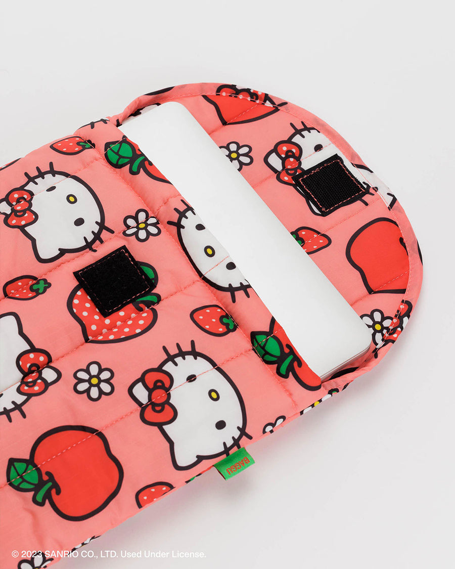 un-velcroed pink 13 in. puffy laptop sleeve with hello kitty face, apple and strawberry print