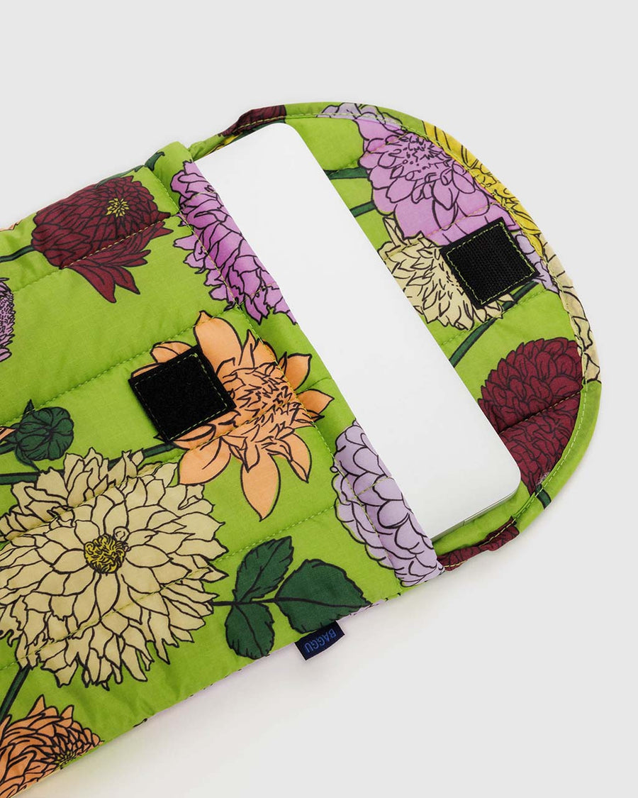 green puffy laptop sleeve with colorful dahlia flower print with laptop inside