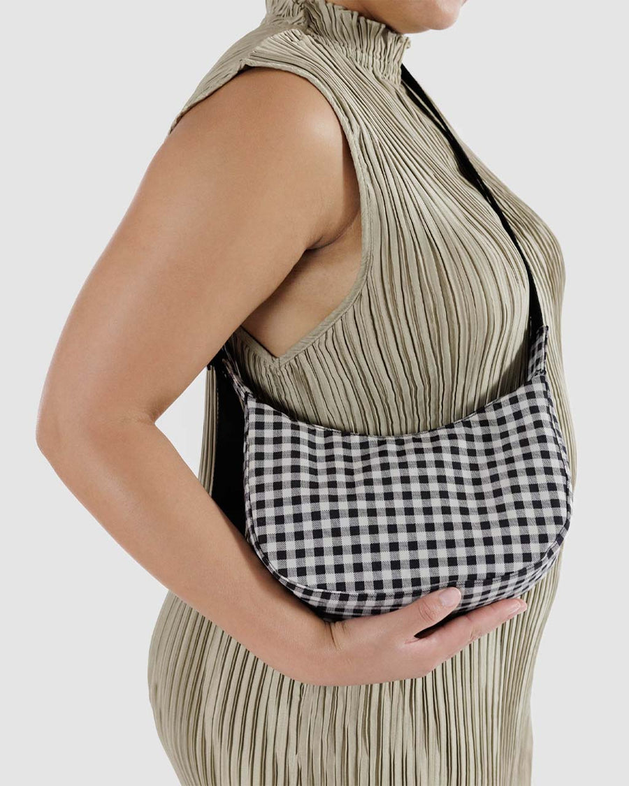 model wearing black and white gingham small nylon crescent bag