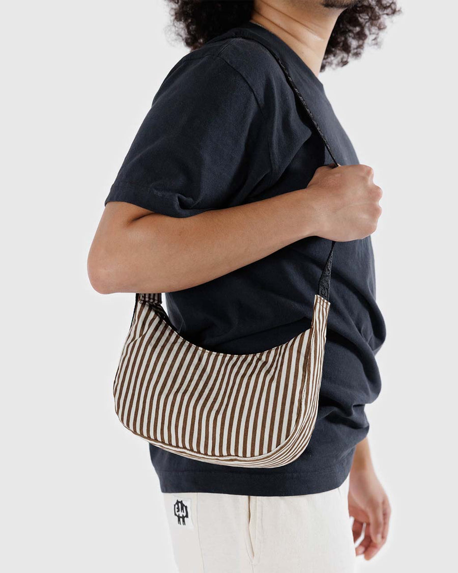model carrying two tone brown vertical stripes small crescent bag