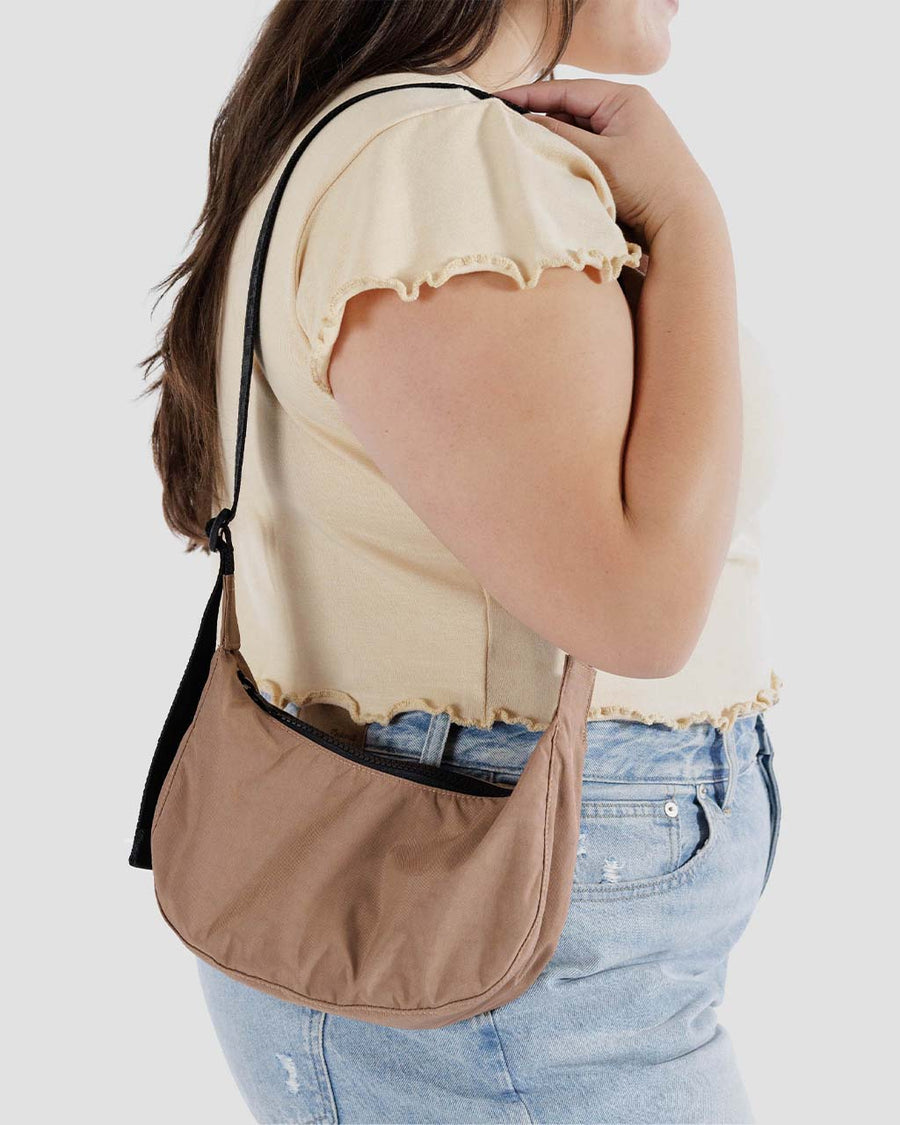 model wearing light brown small nylon crescent bag