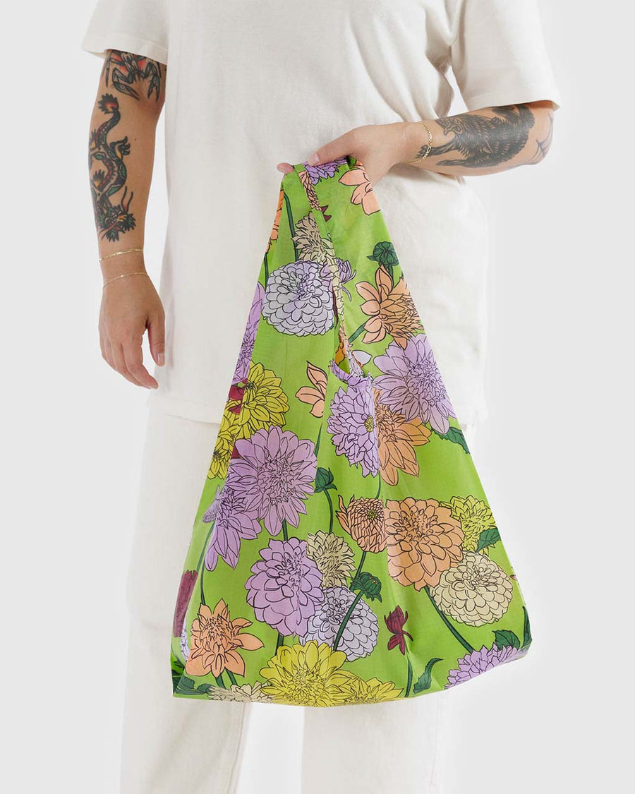 model holding green standard baggu with colorful dahlia flowers