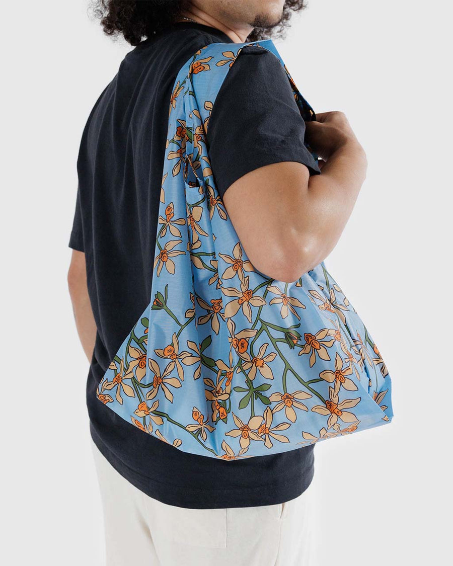 model carrying light blue standard baggu with yellow orchid print
