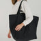 model wearing black large travel cloud bag