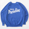 blue sweatshirt with white 'GREETING FROM...PARADISE' across the front