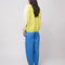back view of model wearing relaxed fit color block sweatshirt with yellow body, white sleeves, teal zipper placket and navy collar