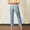 backview of model wearing light denim jeans with raw hem and distressing throughout