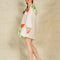 side view of model wearing cream mini dress with exaggerated collar, puff long sleeves and all over abstract tulip print
