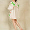 back view of model wearing cream mini dress with exaggerated collar, puff long sleeves and all over abstract tulip print
