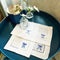 white napkins with dark blue embroidered bows on a table