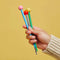 model holding green hair stick with yellow ball on the end