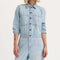 model wearing light denim jumpsuit with button front, patch pockets, collar and long sleeves