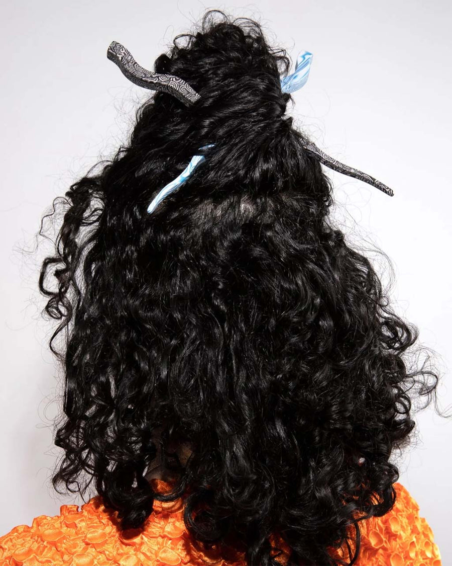 model wearing blue and white swirl large wavy hair stick