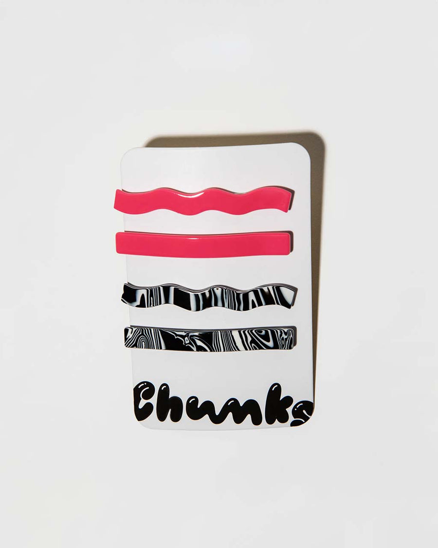 set of four hair clips: hot pink wavy, hot pink straight, black and white swirl wavy, and black and white swirl straight