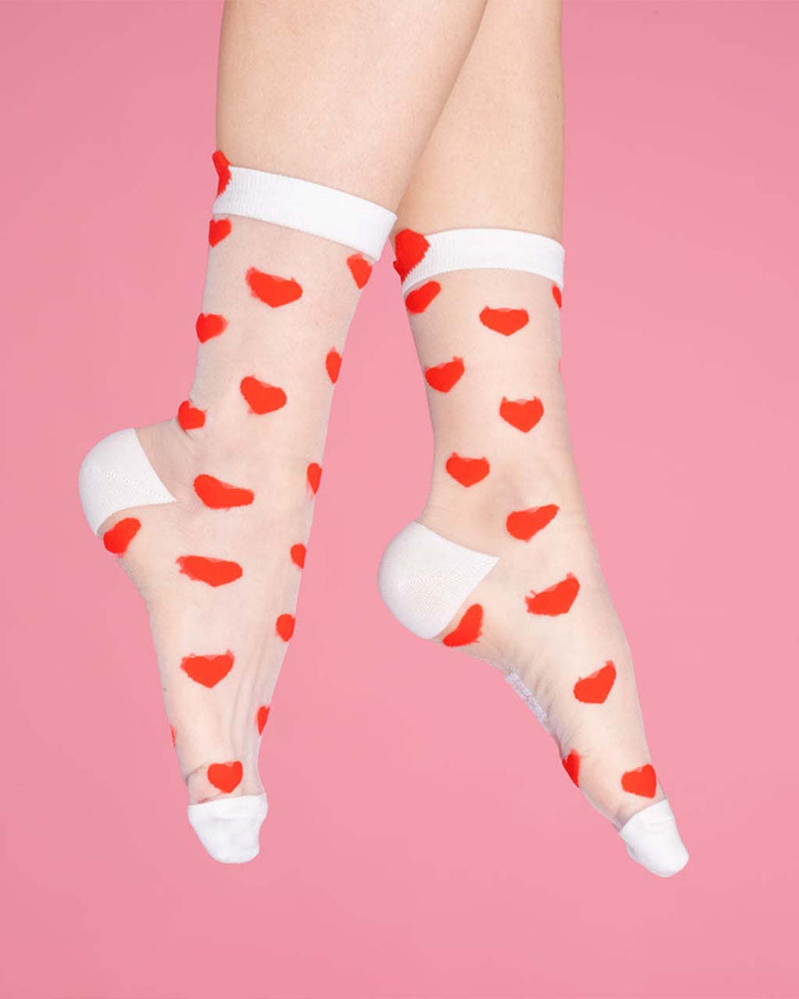 model wearing sheer socks with red heart print and white trim