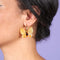 model wearing yellow butterfly earrings with gold hoops