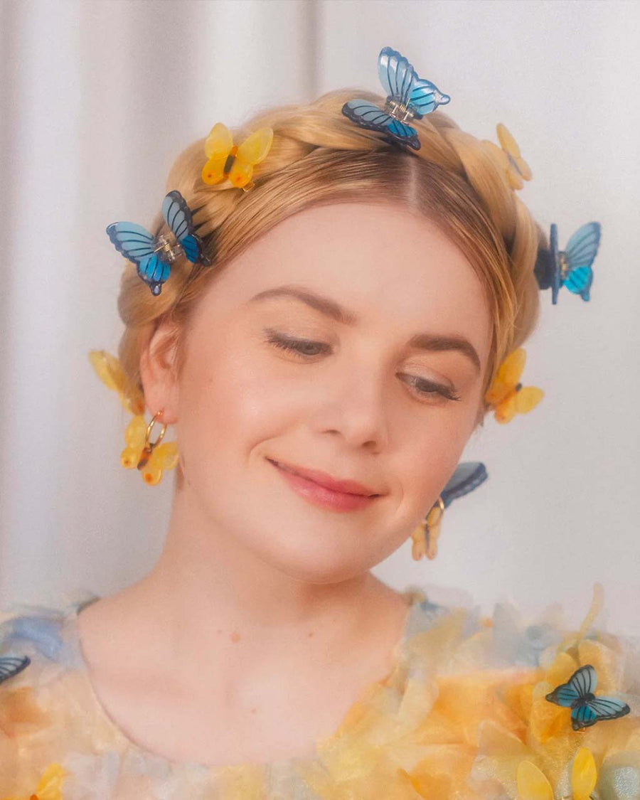 model wearing yellow butterfly earrings with gold hoops