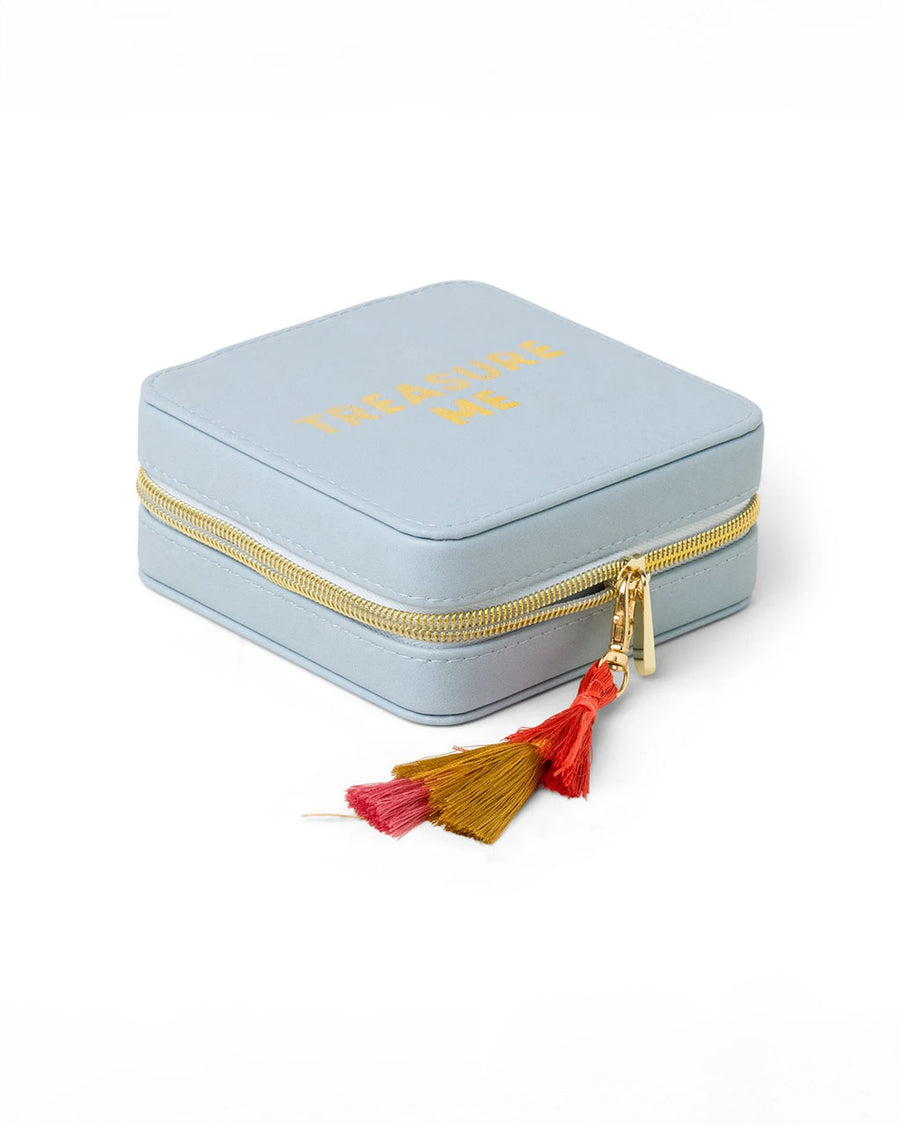 side view of light blue jewelry case with multicolor tassel and gold 'treasure me' across the front