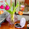 purple glass seashell shaped vase with tulips inside