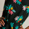 up close of model wearing black tank midi dress with colorful summer fruit print