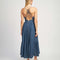 back view of model wearing denim midi dress with button front, spaghetti straps and o-ring back detail