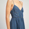 up close of model wearing denim midi dress with button front, spaghetti straps and o-ring back detail