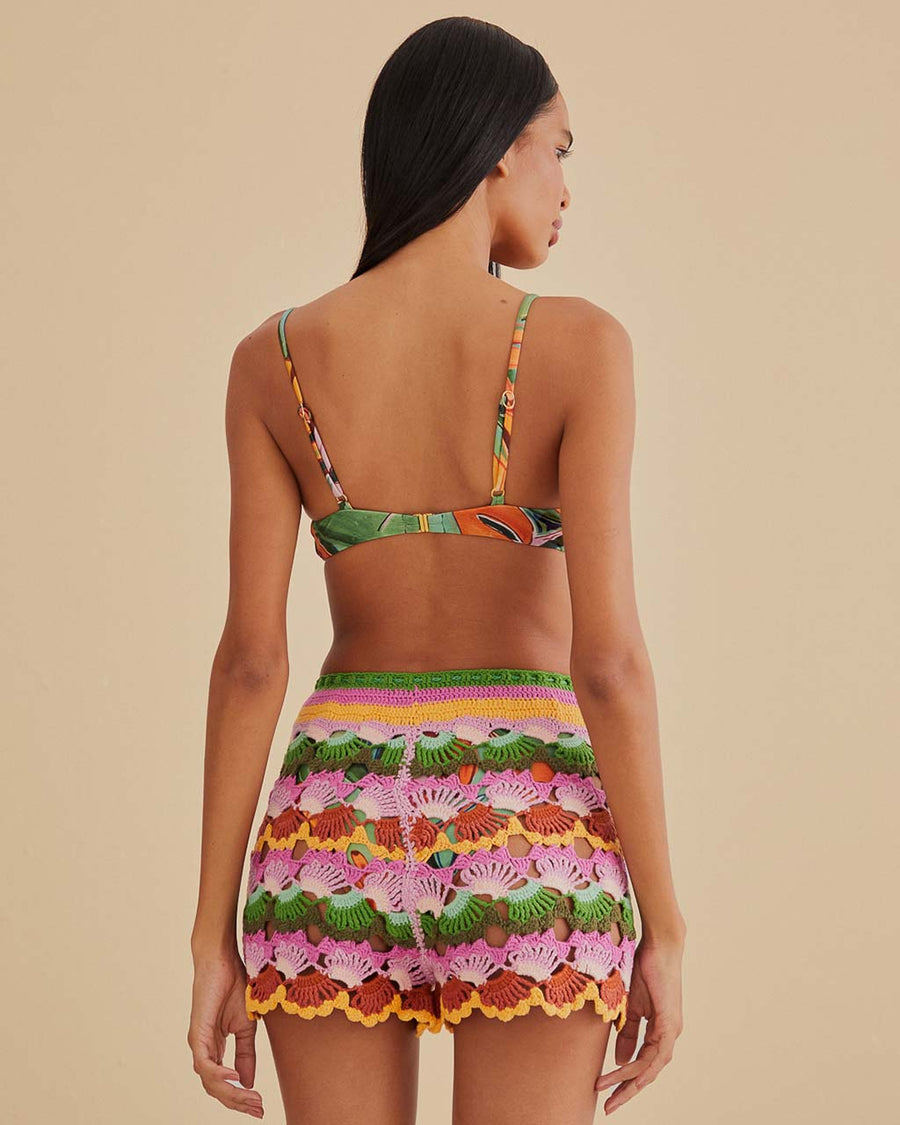 back view of model wearing colorful crochet shorts with crochet tie and scalloped hem