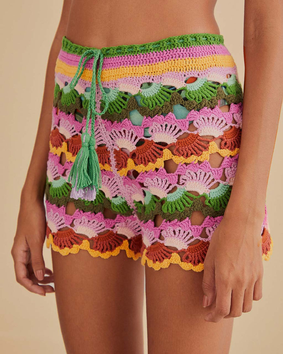 up close of model wearing colorful crochet shorts with crochet tie and scalloped hem
