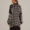 back view of model wearing black oversized cardigan with textured white stripe pattern