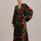 model wearing black maxi dress with puff sleeves, deep v and all over red floral print