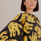 up close of model wearing black long sleeve jumpsuit with abstract banana print